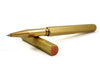 Y Studio Classic Revolve brass rollerball pen with sleek design and smooth writing tip, shown on a white background.