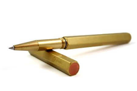 Y Studio Classic Revolve brass rollerball pen with sleek design and smooth writing tip, shown on a white background.