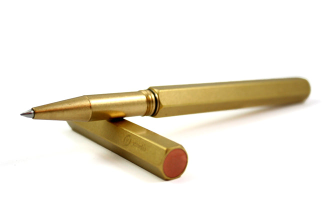 Y Studio Classic Revolve brass rollerball pen with sleek design and smooth writing tip, shown on a white background.