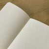 Medium analog memory backup journal by The Mincing Mockingbird with a textured cover and lined pages for note-taking.