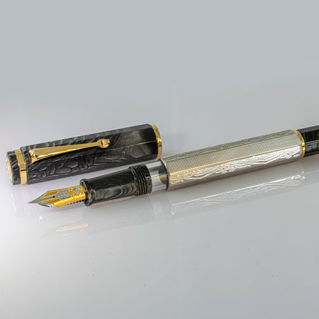 Omas Cobra limited edition fountain pen with sleek black body and gold accents, displayed on a white background.