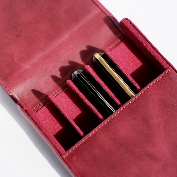 Red leather pen case by Eng Leather Co. with five compartments, designed to securely hold and organize writing instruments.