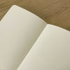 Medium Idea Dump Journal by The Mincing Mockingbird with a textured cover and lined pages for jotting down ideas.