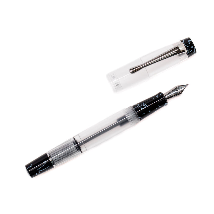 Opus 88 KOLORO black fountain pen with gold accents and transparent grip section, showcasing elegant design.