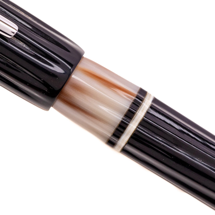 Opus 88 Buffalo Horn Fountain Pen with gold accents and transparent grip section, showcasing its elegant design and craftsmanship.