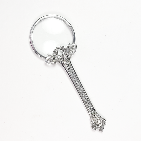 Small Le Potier D'etain magnifying glass with floral handle, featuring a clear glass lens and decorative flower design.