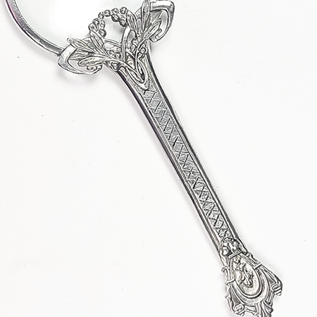 Small magnifying glass with handle featuring a flower design, from Le Potier D'etain, close-up view showing detailed craftsmanship.