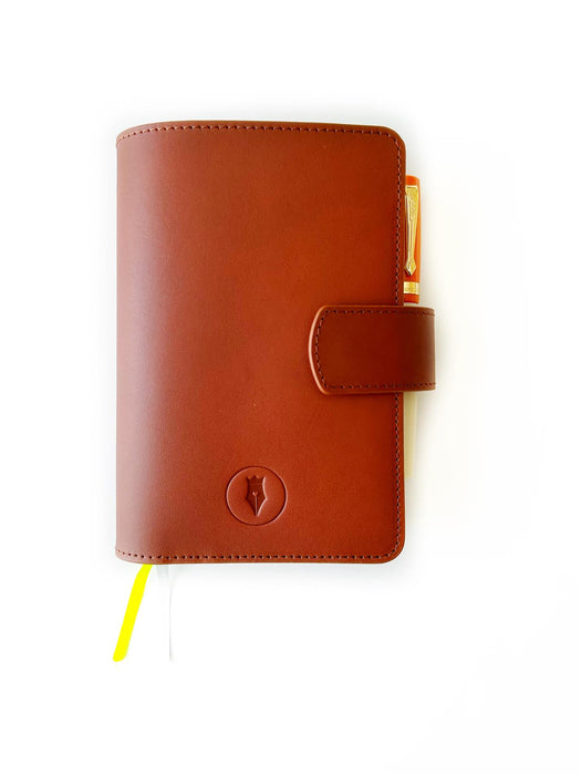 A6 leather journal cover in English tan by Eng Leather Co., featuring a sleek, textured leather exterior and secure strap closure.