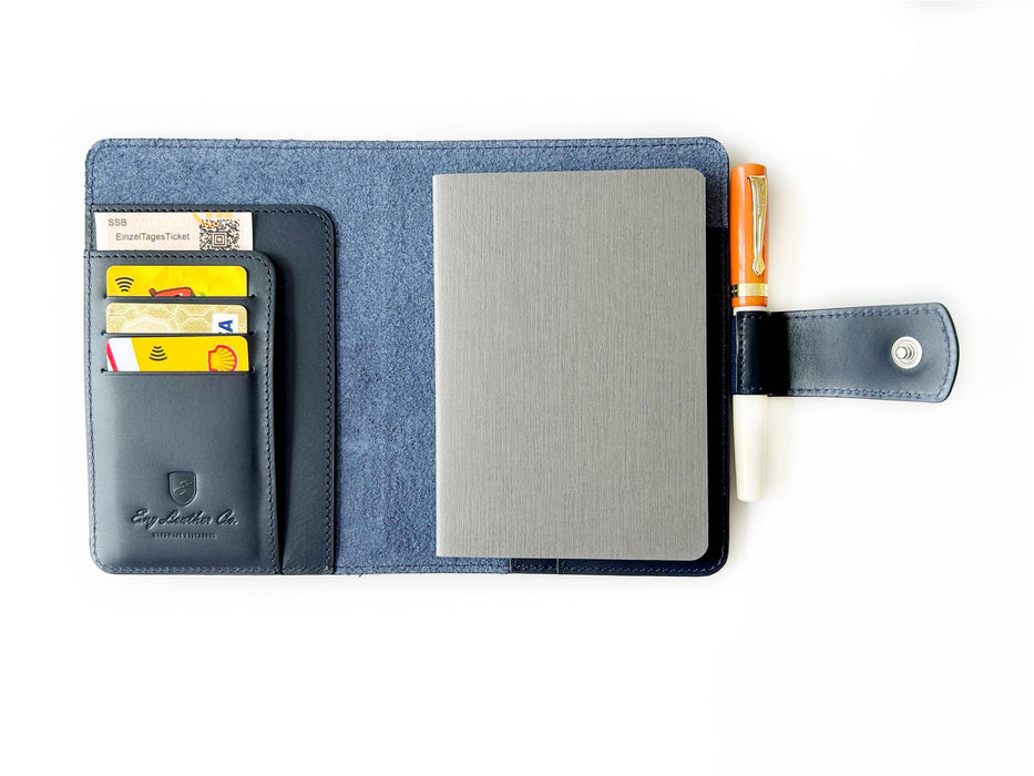 Navy blue leather A6 journal cover by Eng Leather Co. with smooth texture and sleek design, open to show internal pockets.