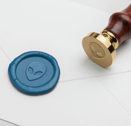 Papier Plume wax seal featuring an alien head symbol, showcasing detailed design on a sealing wax stamp.