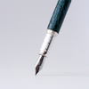 Green Grifos Cocodrie fountain pen with alligator leather grip for smooth writing and elegant design.