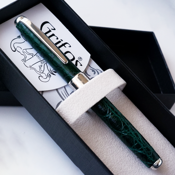 Green Grifos Cocodrie fountain pen with alligator leather grip and gold accents, designed for smooth writing.