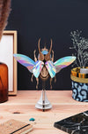 Colorful Paper Atlas Beetle craft by Assembli featuring vibrant rainbow paper wings and detailed body on a white background.