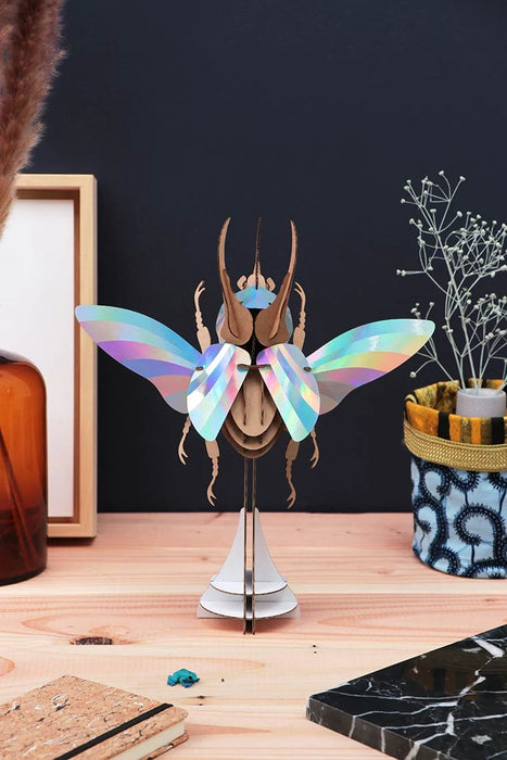 Colorful Paper Atlas Beetle craft by Assembli featuring vibrant rainbow paper wings and detailed body on a white background.