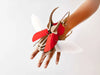 Red-scaled Paper Atlas Beetle craft by Assembli, showcasing detailed, colorful paper art with intricate beetle features.