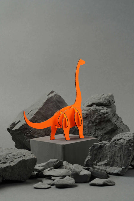 Orange paper Brachiosaurus craft by Assembli, showcasing a detailed dinosaur model made from folded paper.