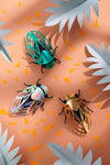 Colorful paper cicada craft by Assembli featuring detailed wings and body, perfect for creative paper craft projects.