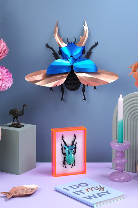 Blue Paper Giant Stag Beetle model by Assembli, showcasing detailed, folded paper insect with large mandibles and intricate wings.