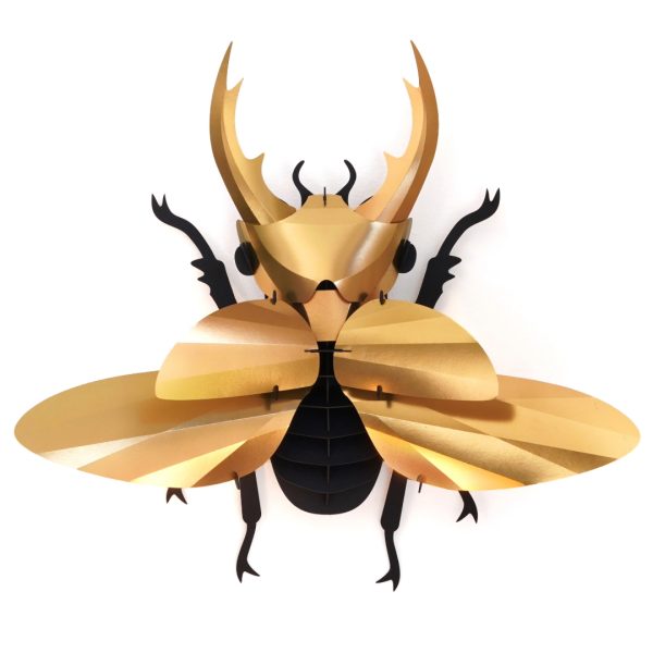 Gold-colored Paper Giant Stag Beetle by Assembli, showcasing detailed paper-crafted insect with textured wings and prominent mandibles.