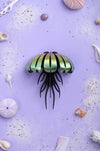 Colorful paper jellyfish craft by Assembli with yellow and orange tissue paper, displayed from a top-down view.