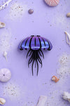 Purple Paper Jellyfish craft by Assembli, viewed from above, showing textured paper and detailed tentacle design.