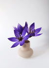 Purple paper flower craft by Assembli, showcasing detailed, handmade paper flower with layered petals for decoration and DIY projects.