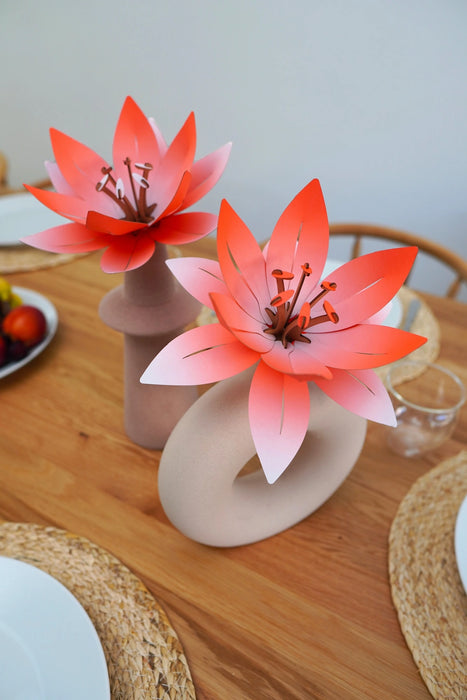 Handmade peach and orange paper flowers for crafts by Assembli, showcasing vibrant, detailed floral designs.