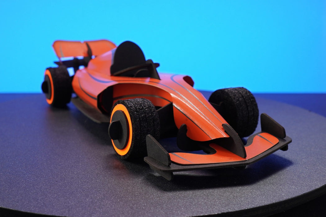 Assembli paper race car craft in flaming orange with front view, showcasing detailed design and vibrant colors.