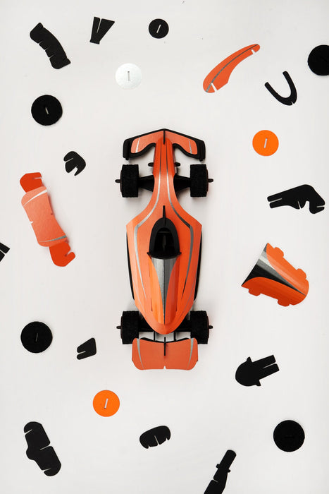 Assembli paper race car craft with flaming orange parts, showcasing assembled paper vehicle with detailed design and vibrant colors.