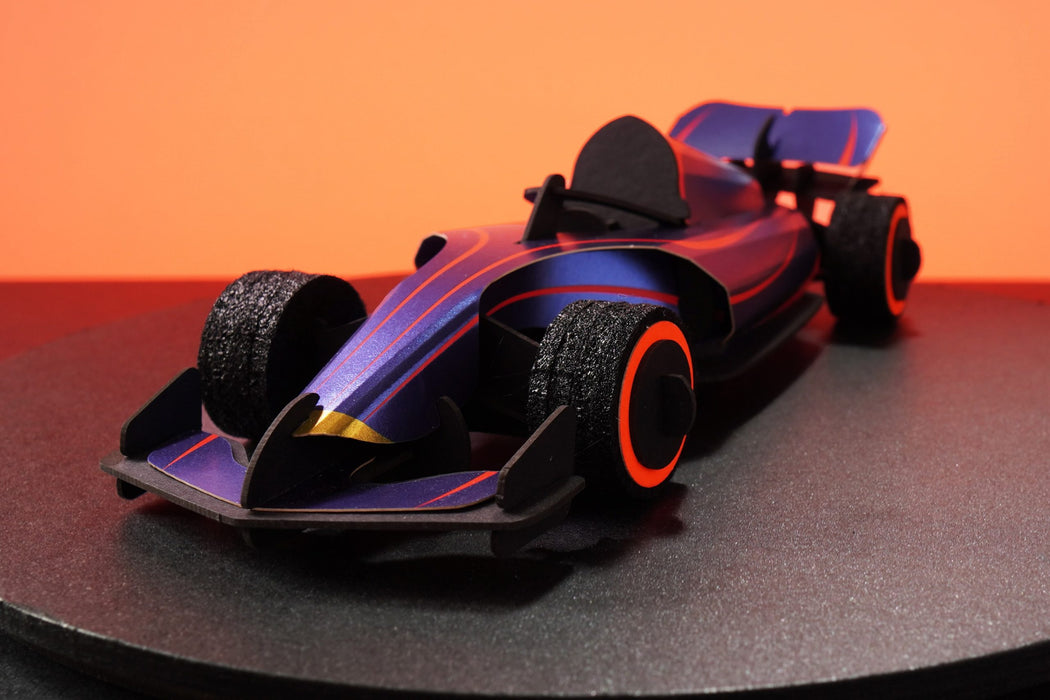 Assembli paper race car craft in vibrant blue, shown from the front with detailed design and assembled for fun racing activities.