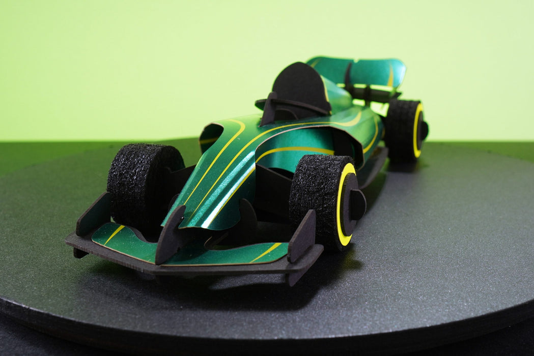 Green paper race car craft from Assembli, showing the front view with detailed racing design and craft paper construction.