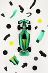 Assembli paper race car craft with green paper parts, showing assembled racing car on a flat surface for creative crafting.
