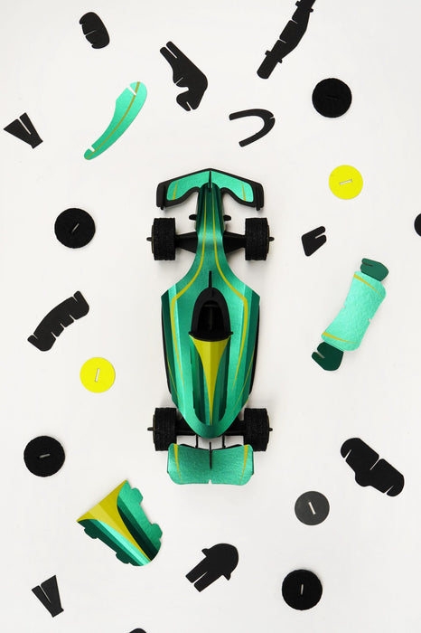 Assembli paper race car craft with green paper parts, showing assembled racing car on a flat surface for creative crafting.