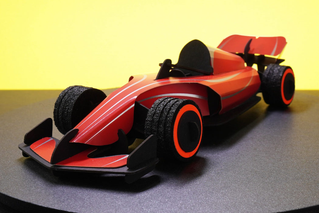 Red paper race car craft by Assembli with detailed front view, showcasing vibrant colors and intricate paper design.