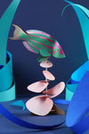 Colorful paper Rainbow Wrasse craft by Assembli, showcasing vibrant folded paper fish with detailed fins and bright rainbow hues.