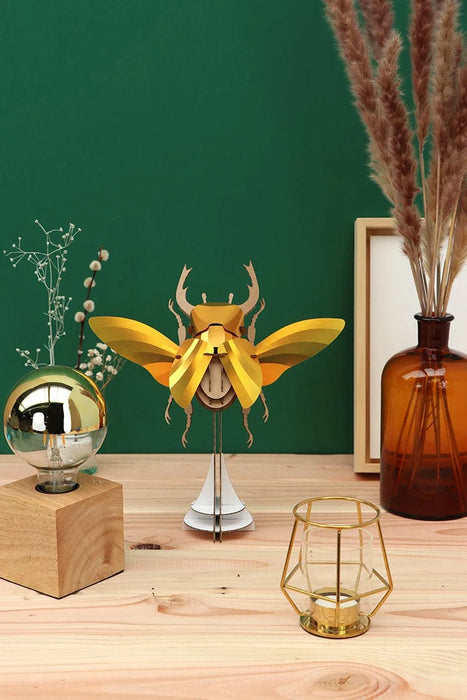 Large paper stag beetle craft by Assembli, featuring detailed gold-colored wings and realistic insect body for creative projects.