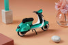 Green vintage paper scooter craft by Assembli, featuring detailed paper construction and retro design elements.