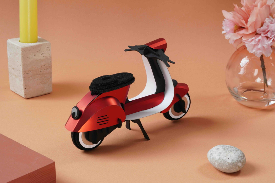 Red vintage paper scooter craft by Assembli, featuring detailed miniature design for creative DIY projects.