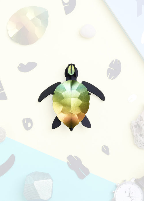 Craft paper sea turtle baby made by Assembli, featuring colorful paper in a cute sea turtle design for arts and crafts projects.