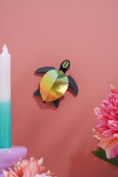 Craft paper sea turtle baby made by Assembli, featuring colorful paper layers and detailed shell design for arts and crafts projects.