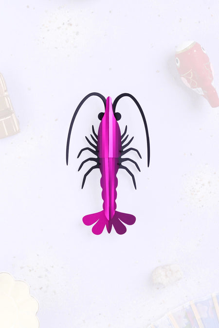 Pink paper shrimp craft by Assembli, showcasing a detailed, folded paper shrimp made for creative arts projects