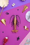 Yellow paper shrimp craft by Assembli, shown from a top-down view, featuring detailed paper textures and intricate design.