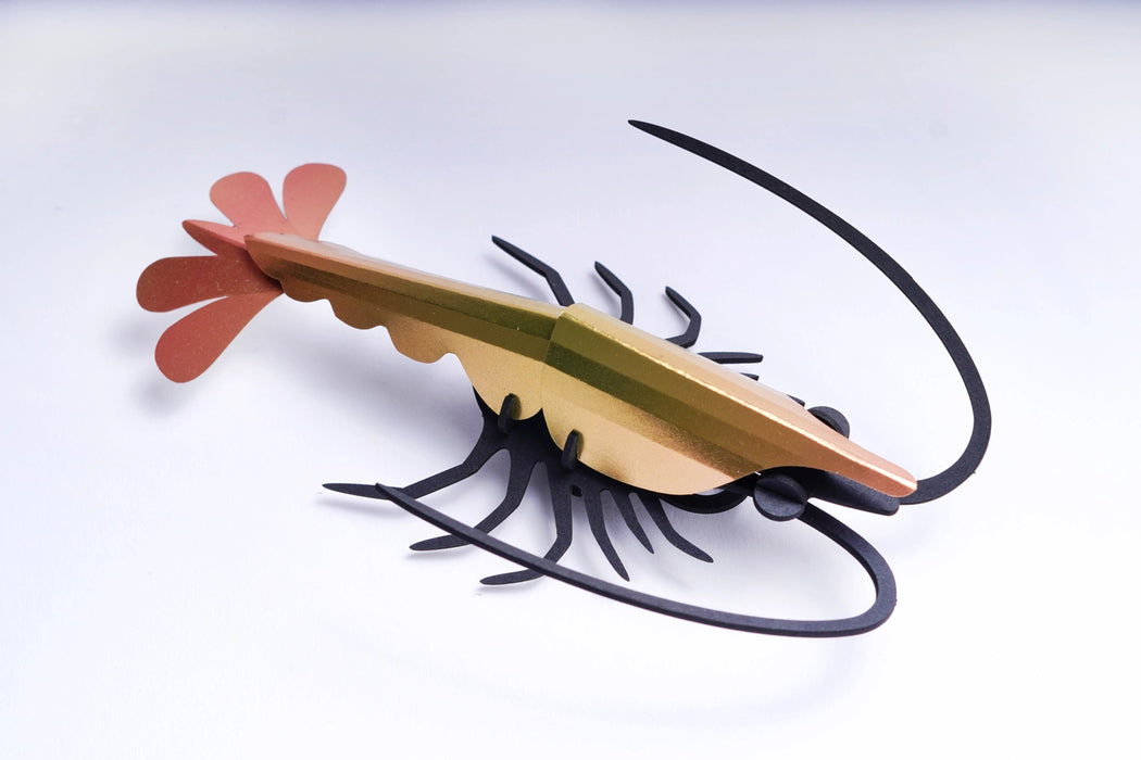 Yellow paper shrimp craft made with folded paper, created by Assembli, showcasing detailed origami-style design.