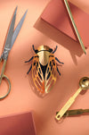 Gold paper cicada craft by Assembli, featuring intricate folded paper wings and detailed body, perfect for creative projects.