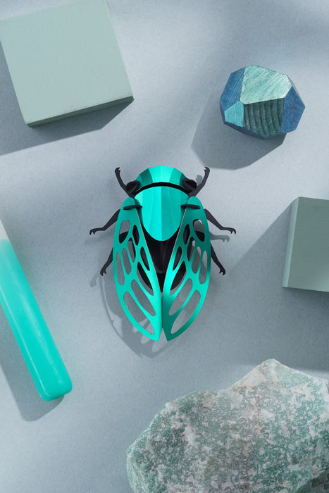 Green paper cicada craft by Assembli, showing detailed folded paper wings and body, perfect for DIY craft projects.