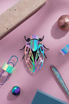 Colorful paper cicada craft by Assembli featuring rainbow paper wings and detailed body, perfect for creative projects.