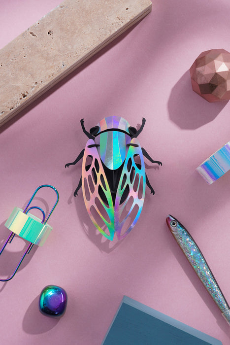 Colorful paper cicada craft by Assembli featuring rainbow paper wings and detailed body, perfect for creative projects.
