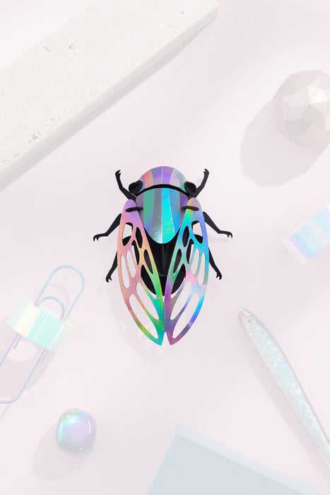 Colorful paper cicada craft by Assembli featuring vibrant rainbow paper wings and detailed body, perfect for creative projects.