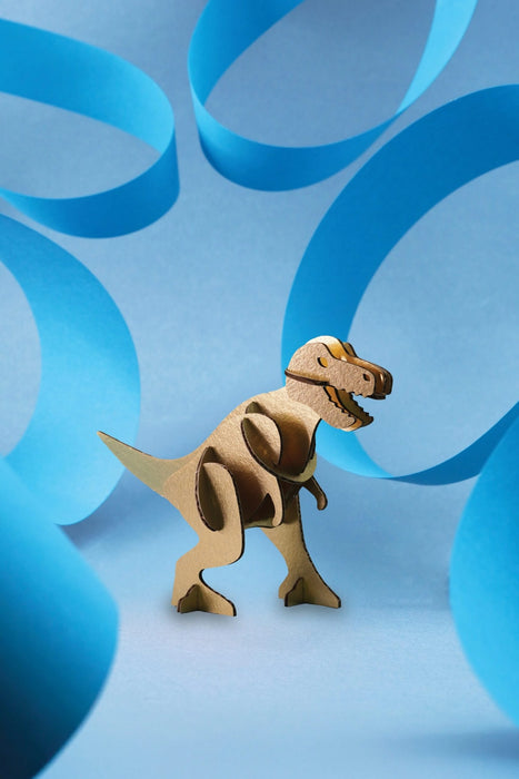 Gold paper Tyrannosaurus craft by Assembli, featuring a miniature T-Rex design made of folded paper.