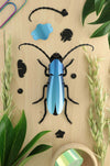 Blue Paper Rosalia Beetle craft made by Assembli, showcasing detailed paper art with vibrant blue and intricate wing patterns.